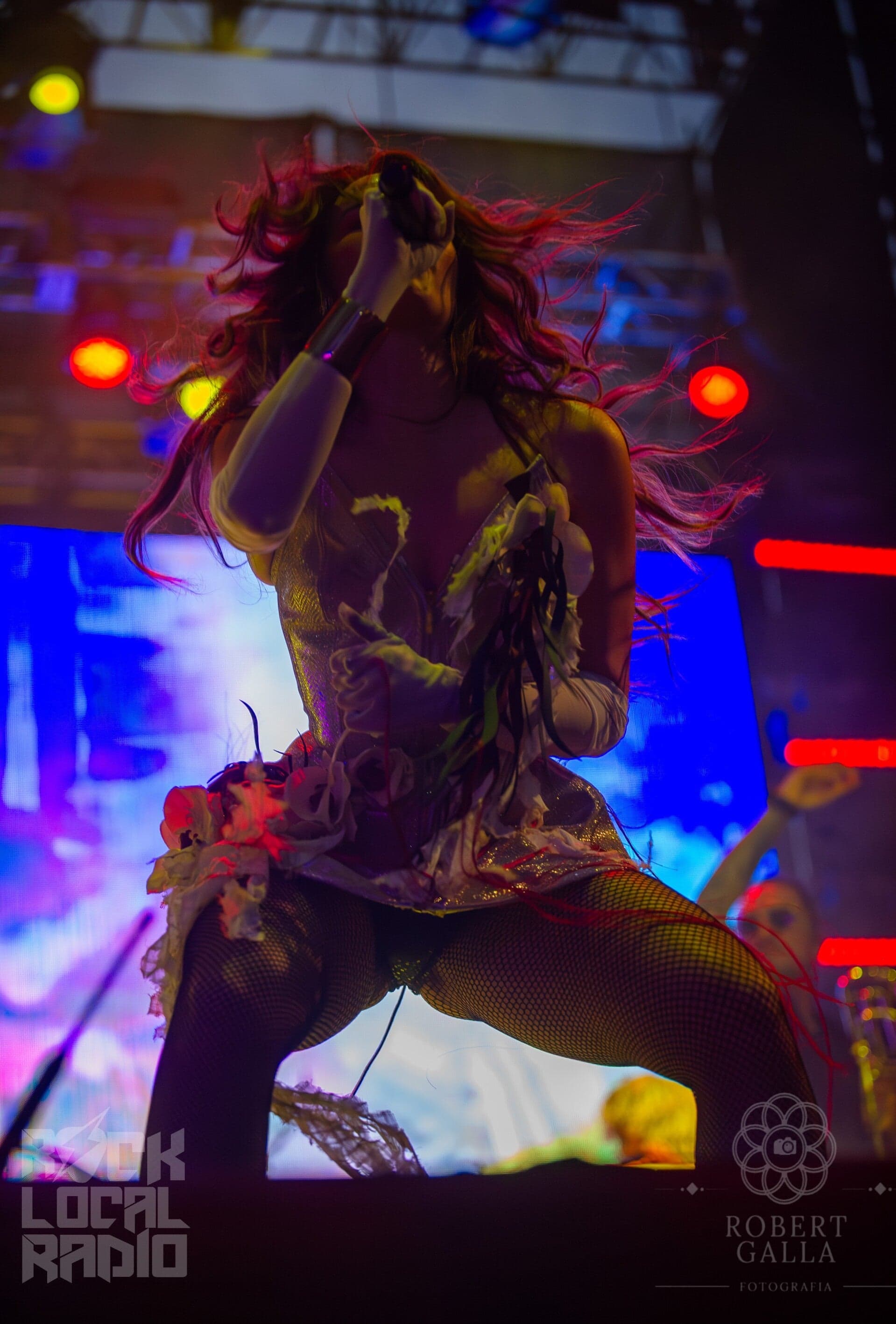 A singer performs under saturated stage lighting at Isle of Light 2025