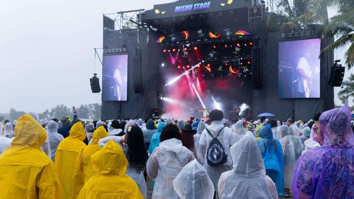Festival attendees in rain gear watch the Mishu stage at Isle of Light 2026