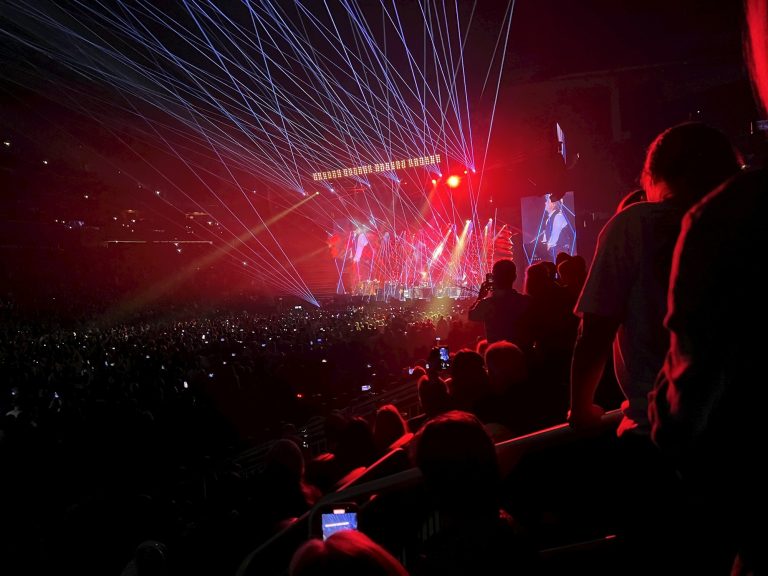 People at a music concert with laser show